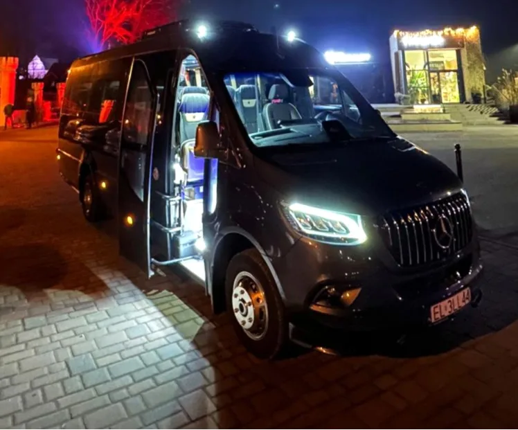 Minibus nocą z podświetlonym wejściem przed lokalem